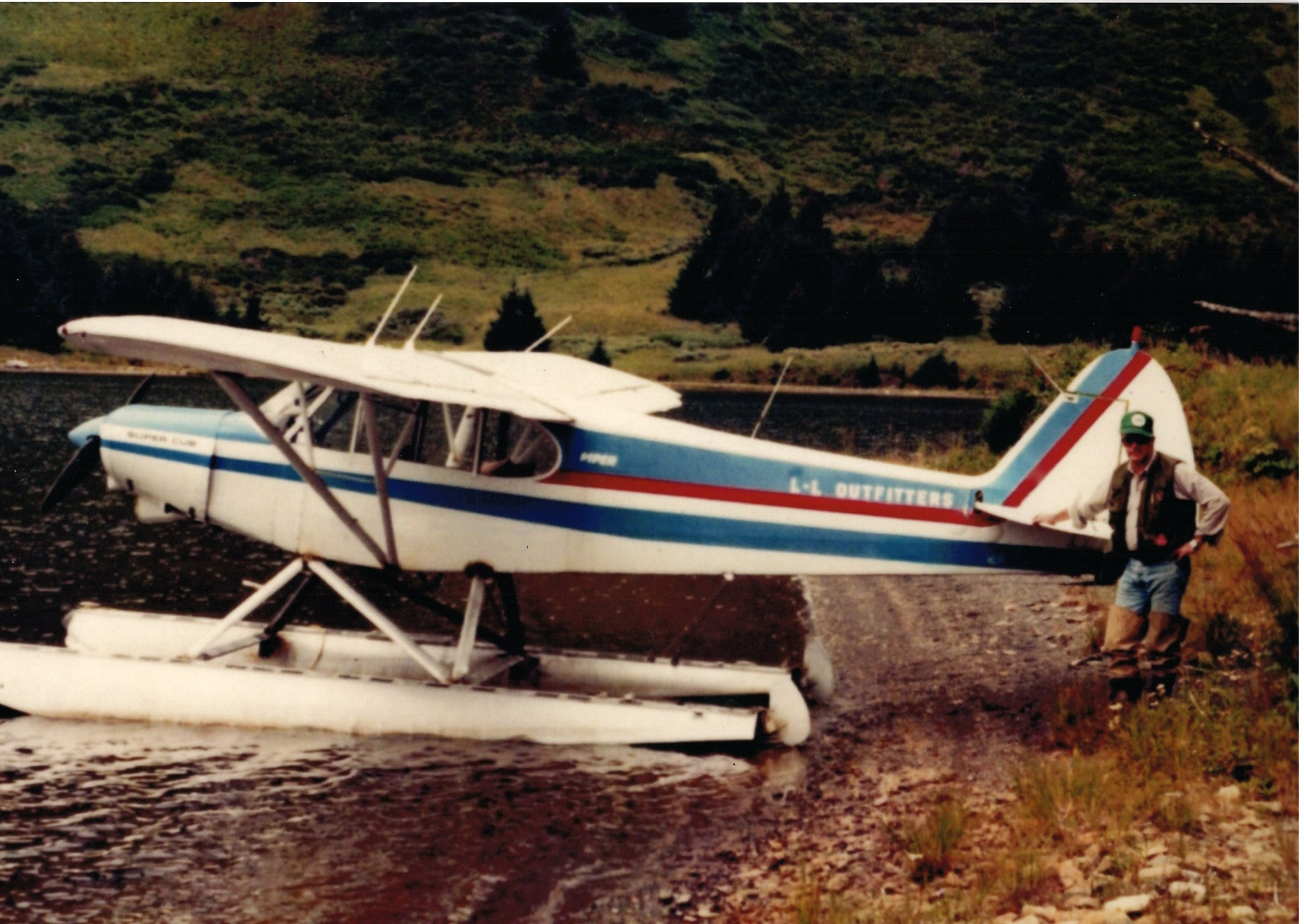 Burdette Jack Lechner beside a floatplane on a Kodiak shore
