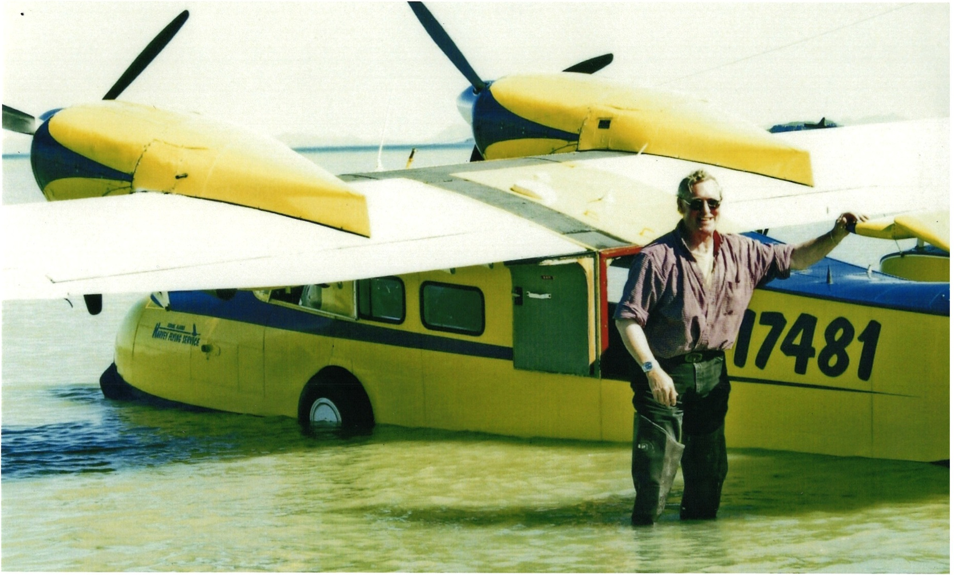 Charles Steve Harvey standing beside a twin-engine floatplane